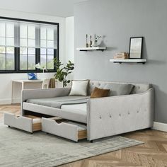 a living room scene with focus on the couch and storage drawer under the sofa's pull out bed