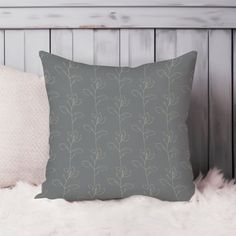 a gray pillow sitting on top of a white furnishing next to a wooden headboard