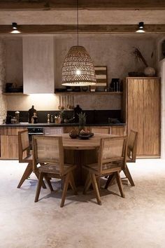 a table and chairs in a room with lights on the ceiling above it, next to an oven