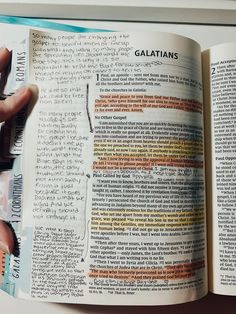 an open book with the words galatians written on it and two hands holding scissors