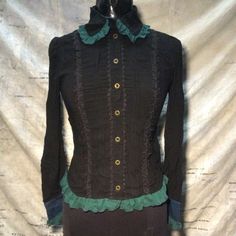 A Brand New Elegant Blouse From The Studio Of Japanese Designer H.Naoto. A Black Blouse With Green Trim And Lace Colors Combination. The Extra Fancy Shoulder Piece Has Intricate Black Lace Overlay The Teal Print Pattern And A Tie. This Shirt Has Many Detailed And Ornate Design Elements Throughout. Measurements: Between Shoulder Seams 14in Pit To Pit 17in Sleeve Length 24in Front Length 23in Original Retail Is $227 Fitted Black Blouse With Buttons, Gothic Fitted Tops For Workwear, Collared Black Blouse With Buttons, Fitted Long Sleeve Tops In Dark Academia Style, Dark Academia Fitted Long Sleeve Tops, Fitted Long Sleeve Dark Academia Top, Gothic Blouse Victorian, Gothic Stretch Tops With Lace Trim, Spring Gothic Blouse With Ruffles