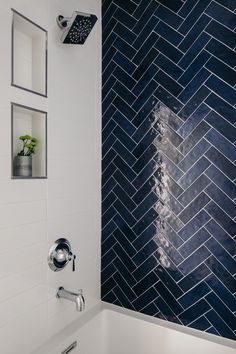 a white tub sitting next to a blue tiled wall