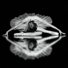 a ballerina is bending down on the floor in front of a black and white background