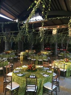 tables and chairs are set up with green tablecloths for an elegant dinner party