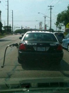 a police car is hooked up to a gas pump