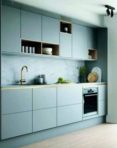 a kitchen with gray cabinets and white counter tops