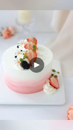 a white and pink cake with strawberries on top