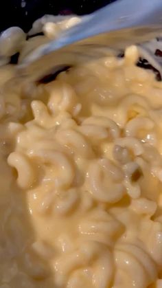 macaroni and cheese being mixed together in a bowl