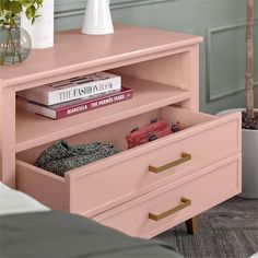 a pink dresser with books and magazines on it