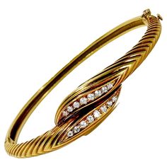 This lovely Mid-20th Century 18k yellow gold hinged bangle bracelet with diamonds exhibits true French Panache. It is deftly crafted with attention to details. At the center, sixteen brilliant cut diamonds are set and have a total approximate weight of .50ct. Overall diamond quality is G color and VS1 clarity. The plunger tongue is stamped with French touch marks that indicate the bracelet was made in France specifically for export. A high grade figure eight safety clasp offers additional security. Inside circumference is 6 1/2 inches. Gross weight 21.20 grams. Bracelet With Diamonds, Gents Ring, Vintage Bangle Bracelets, Vintage Bangles, Diamond Bangles Bracelet, Diamond Bangle, Hinged Bangle, Brilliant Cut Diamond, Bangle Bracelet