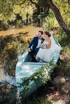 a bride and groom are sitting in a small boat