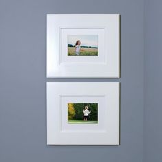 two white framed pictures hanging on the wall