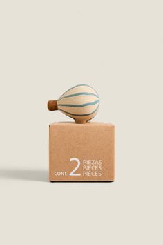 a wooden object sitting on top of a cardboard box with the number two in it