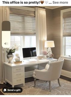 a white desk with a computer on top of it in front of two large windows