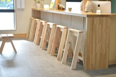 a row of wooden stools sitting in front of a counter