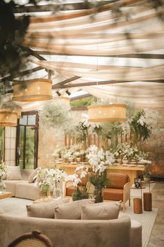 a living room filled with lots of furniture and flowers in vases on the tables