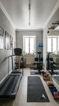 a home gym with treadmills, exercise mats and other equipment in the room