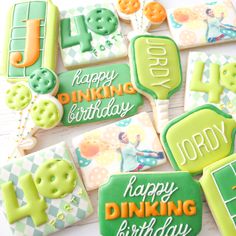 decorated cookies are arranged on a table for a tennis themed birthday party with the words happy, drinking, and playing cards