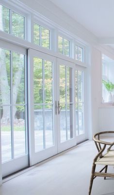 an empty room with white walls and glass doors