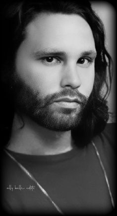 a black and white photo of a man with long hair wearing a t - shirt