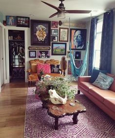 a living room filled with furniture and lots of pictures on the wall next to a window