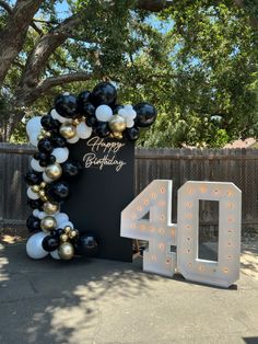 a black and white balloon arch with the number forty