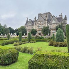 a large building with lots of hedges in front of it