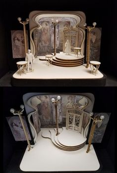 an elaborately designed display case with gold and white furniture