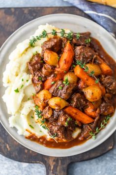 a white plate topped with mashed potatoes and beef