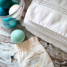 some bath balls and towels on a marble counter with a glass jar full of them