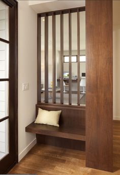 a wooden bench sitting in the middle of a room next to a window with bars on it