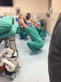 several doctors in scrubs are performing surgery