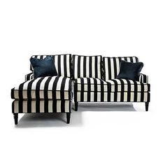 a black and white striped couch sitting next to a blue pillow on top of it