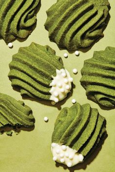 green cookies with white frosting on a table