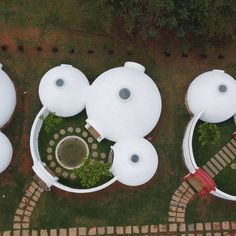 an aerial view of some white structures in the grass