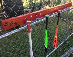 several baseball bats are lined up in a fenced - in area with numbers on them