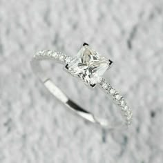 a white gold ring with a princess cut diamond