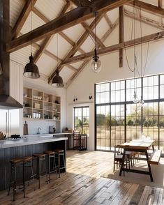 a large open kitchen and dining room with wood flooring in an old farmhouse style home