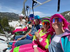 some people are sitting on a ski lift and one is holding a drink in her hand