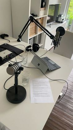 a laptop computer sitting on top of a desk next to a microphone and headphones