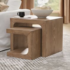 a wooden table with a bowl on top of it next to a couch and window