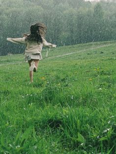 a girl running in the rain with an umbrella