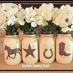 four mason jars with white flowers in them