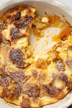 a baked dish with powdered sugar on top in a white casserole dish