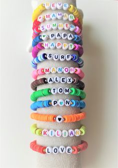 a stack of bracelets with the words happy on them in different colors and shapes