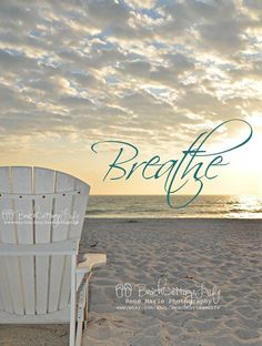 a white chair sitting on top of a sandy beach next to the ocean at sunset