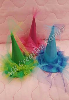 three colorful hats sitting on top of a bed