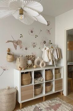 a white room with baskets on the floor and wall papered behind it, along with an area rug