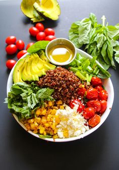 a salad with tomatoes, avocado, corn and dressing