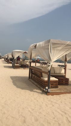 the beach is lined with lounge chairs and umbrellas